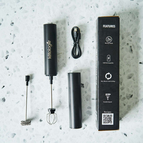 USB rechargeable frother/mixer with interchangeable heads and charging cable on a counter.