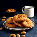Peanut butter cookies made with powdered peanut butter, served on a plate with a cup of milk and peanuts in the background.