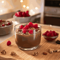 Micellar casein protein shake with raspberries and nuts in a glass.