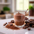 Unflavored beef protein powder shake with chocolate pieces on a kitchen counter.
